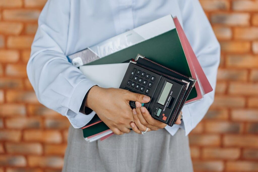 Tax consultant holding documents and a calculator, representing accounting services, payroll management, and bookkeeping support.